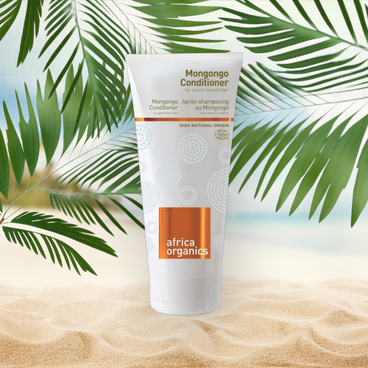 Pureday En tube Africa Organics Mongongo Conditioner 200 ml står i midten med en baggrund af sandstrand og palmeblade, hvilket antyder naturlige, tropiske omgivelser.